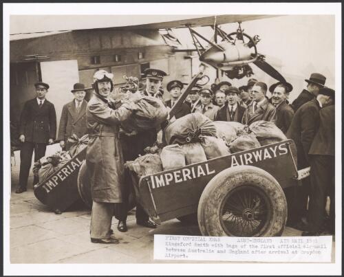 Charles Kingsford Smith with bags of the first official air mail between Australia and England after arrival at Croydon Airport, Queensland, 1931 [picture] / Cliff Postle