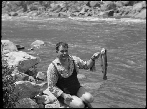 Canon Edwards holding a fish on the banks of the Murrumbidge River, Australian Capital Territory, ca. 1935 [picture]