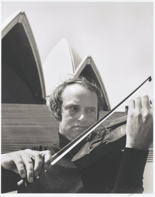 John Painter playing the violin at the steps of Sydney Opera House, 1975 [picture] / Douglas Thompson