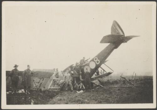 Airmen of 3 Squadron, Australian Flying Corps, standing next to a Royal Aircraft Factory RE8 biplane crashed nose down in barbed wire, France, 1917 [picture] / John Joshua