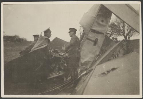 Three officers examining a crashed military biplane, South Carlton, England, 1917 [picture] / John Joshua