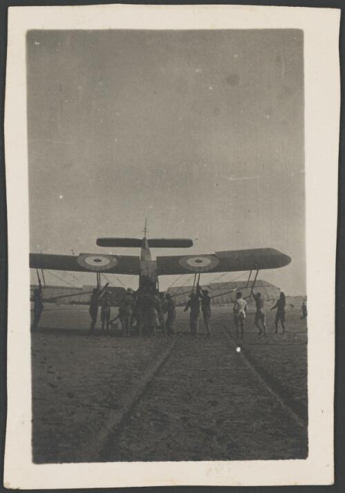 Members of 3 Squadron, Australian Flying Corps, pushing a crash landed Royal Aircraft Factory B.E.2c, 4145, biplane into an upright position, France, 1917 [picture] / John Joshua
