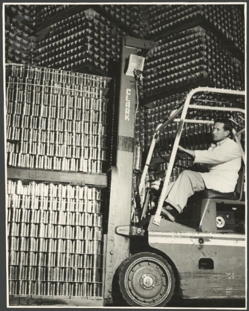 Worker in fork lift moving cans to storage in preparation for the start of the processing season at Leeton Co-operative Cannery, New South Wales, ca. 1968 [picture] / Barry Wilton