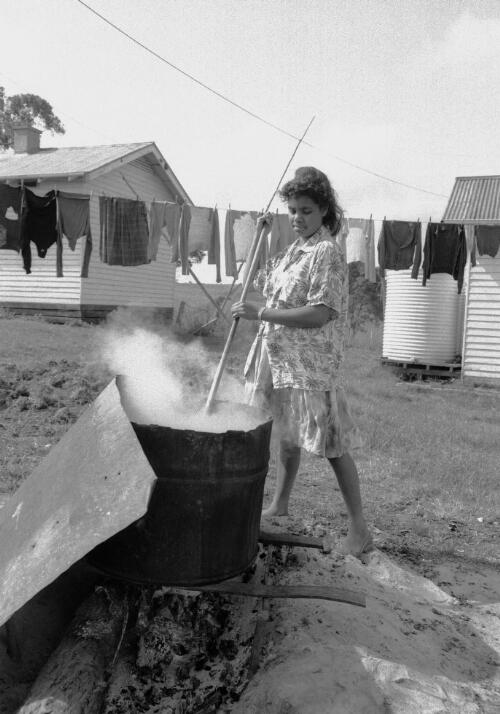 A young Aboriginal woman tending an incinerator, Lake Tyres Mission, Victoria, ca. 1965 [picture] / Albert W. Brown