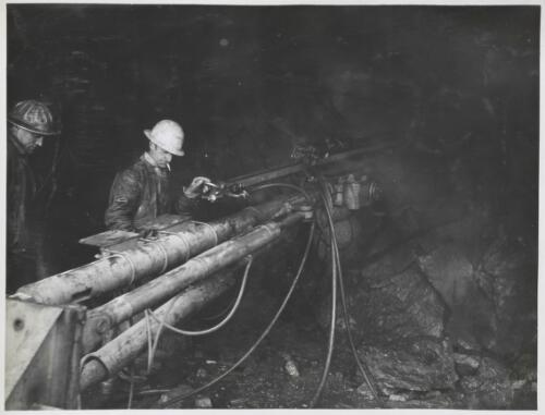 Men rockdrilling at Geehi Dam in river diversion tunnel, Snowy Mountains, New South Wales, July 1962 [picture] / Thiess Bros Pty Ltd