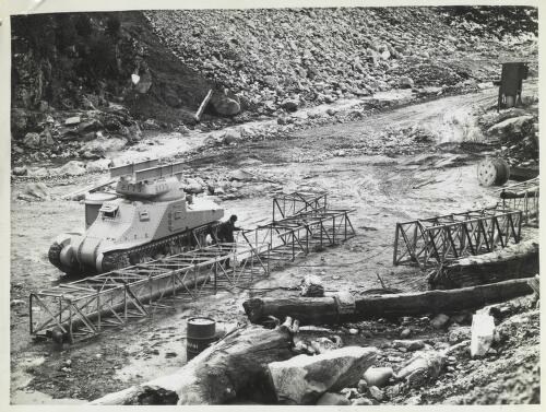 Sluicing equipment being assembled at Geehi Dam site, with old WWII tank used for transport, Snowy Mountains, New South Wales, June 1963 [picture] / Thiess Bros Pty Ltd