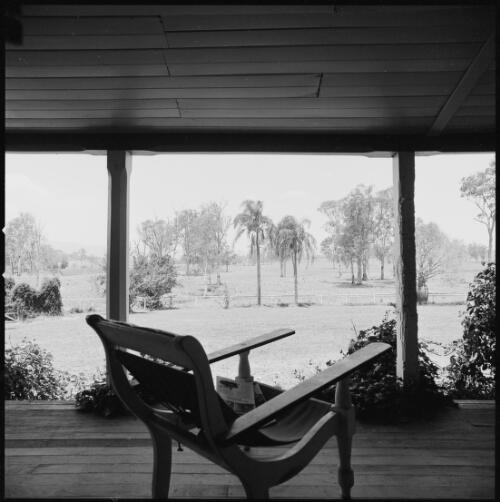 Chair on verandah overlooking the garden of Mundoolun Homestead, Beaudesert, Queensland, ca. 1970 [picture] / Wes Stacey