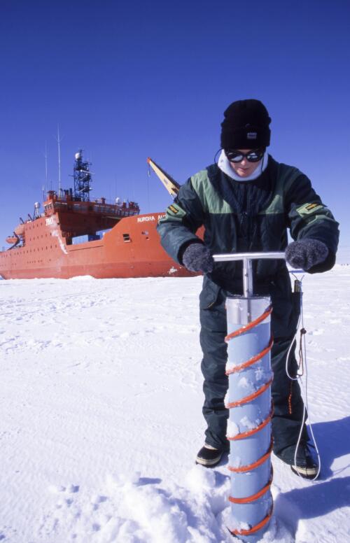 Research assistant Naomi Petrie drilling an ice core sample with the RSV Aurora Australis in the background, Antarctica, October 2002 [picture] / Doug Thost