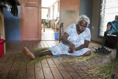 Evelyn Omeenyo at work weaving a basket from strands of dry grass, Lockhart Rivert Art Centre, Lockhart River, Cape York, Queensland, 19 October 2010 [picture] / Dave Tacon