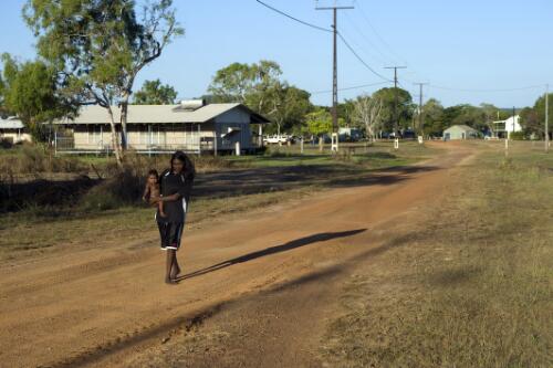 Stacey Singer and son Damian walking through Wudikapildiyerr outstation, Daly River, Northern Territory, 29 June 2010 [picture] / Darren Clark