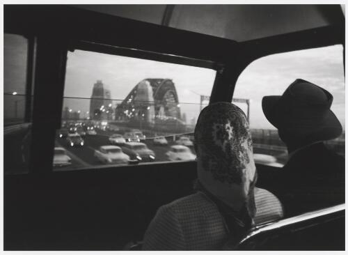 A couple in a bus approaching the Sydney Harbour Bridge, Sydney, 1964 / Robert McFarlane