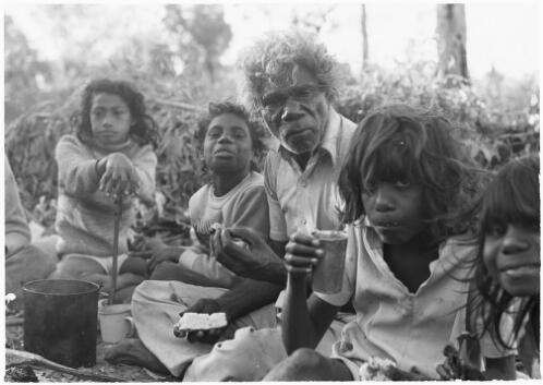 Four girls sitting around a campfire with a local Aboriginal elder, Mornington Island, Queensland, approximately 1980 / Gregory Owen