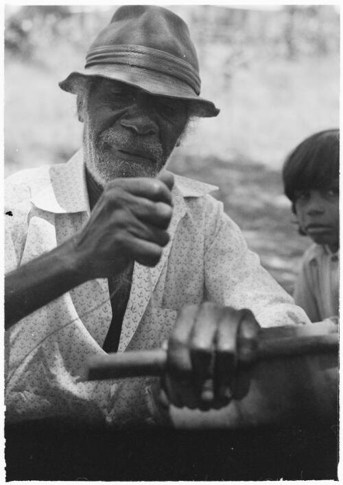 Aboriginal elder Henry Peters preparing a section of bark for painting, Mornington Island, Queensland, approximately 1980 / Gregory Owen
