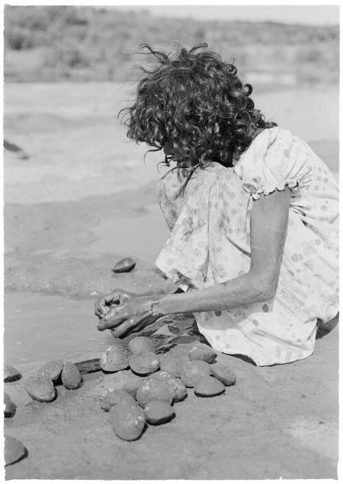 Girl cleaning shells collected from around mangrove roots, Mornington Island, Queensland, approximately 1980 / Gregory Owen