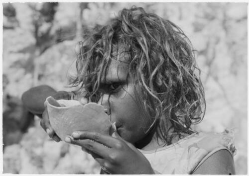 Girl drinking from an improvised shell cup, Mornington Island, Queensland, approximately 1980 / Gregory Owen