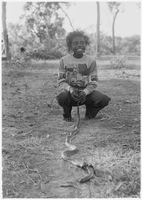 Child holding a dead snake, Mornington Island, Queensland, approximately 1980 / Gregory Owen