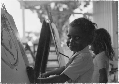 Young boy painting at an easel, Mornington Island, Queensland, approximately 1980 / Gregory Owen