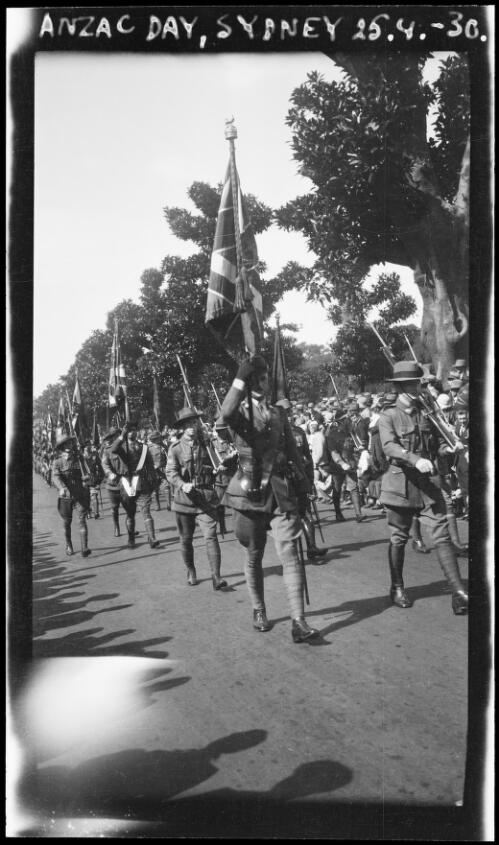 Soldiers carrying rifles and British flags during an Anzac Day march, Sydney, 1930