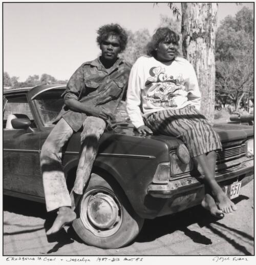 Young Aboriginal adults Cyril and Joscelyn sitting on the bonnet of a car, Ernabella, South Australia, 1987 / Joyce Evans