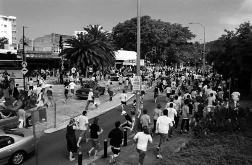 Hundreds of rioters run up Cronulla Street for the Cronulla Railway station where an attack on men of Middle eastern appearance followed, during the race riots in Cronulla, 11 December 2005 [picture] / Andrew Quilty