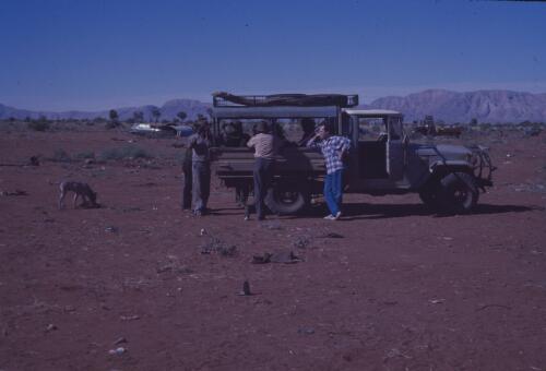 Men standing around a vehicle at Papunya Tula, Northern Territory, 1980 [transparency] / Andrew Crocker