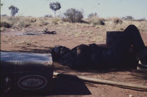 Aboriginal man resting in the shade, Papunya Tula, Northern Territory, 1981 [transparency] / Andrew Crocker