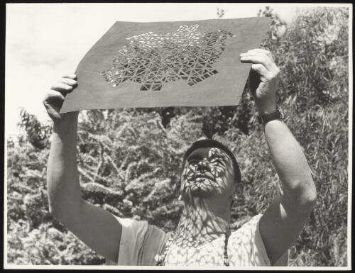 Len French showing the effects of sunlight filtering through a geometric patterned template held aloft, Heathcote, Victoria, 14 January 1967 [picture]