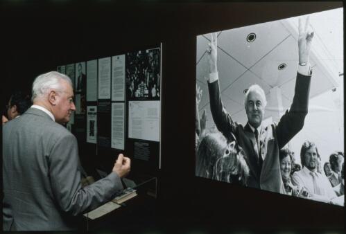 Gough Whitlam examining an exhibit during the opening of the Freedom's on the Wallaby exhibition at the National Library of Australia, Canberra, 8 October 1991 [transparency] / Loui Seselja