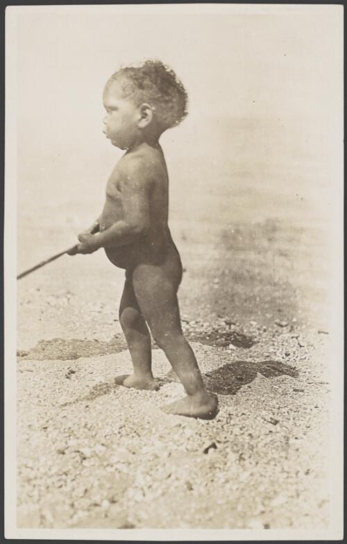 Aboriginal toddler walking and holding a stick, 1914 [picture] / Frank Hurley