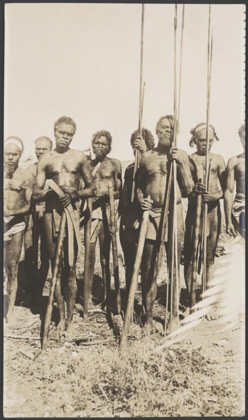 Group of Aboriginal men holding spears, clubs and boomerangs, 1914 [picture] / Frank Hurley