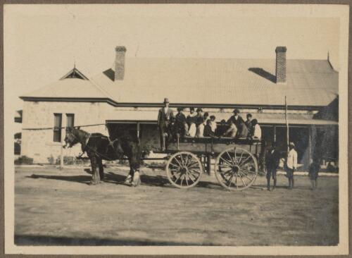 Young Aboriginal men and teacher on back of horse-drawn cart outside Koonibba Children's Home, South Australia