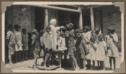 Nurse Semmler dispensing medicine to the children during the whooping cough epedemic, Koonibba, South Australia