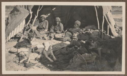 Three women and their dogs sitting in front of a wurly, Koonibba region, South Australia