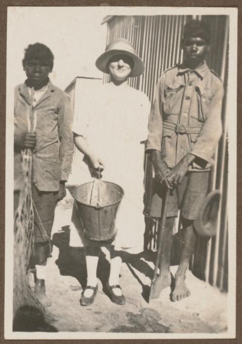 Staff member and two boys standing in the yard, Koonibba Children's Home, South Australia