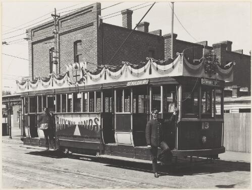 A tram with St Kilda Road on its side and Glenferrie Road on the front bearing a Buy war bonds billboard, Melbourne, 1918