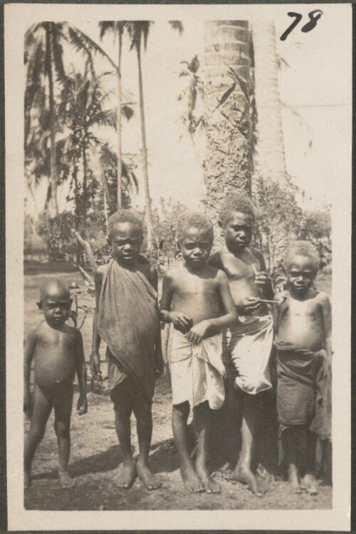 Five small boys near a palm tree, New Britain Island, Papua New Guinea, approximately 1916