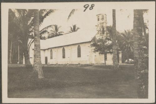 Stone mission church with palm trees, New Britain Island, Papua New Guinea, probably 1916