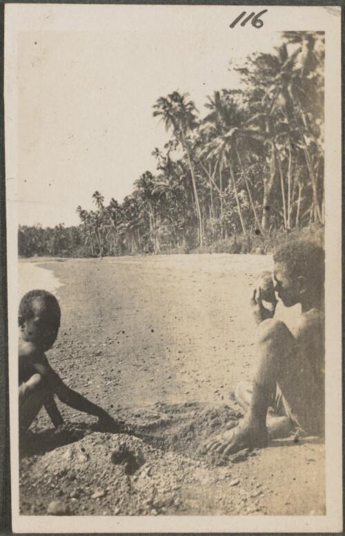 Two Papuan boys, one drinking from a half coconut shell, New Britain Island, New Guinea, probably 1916