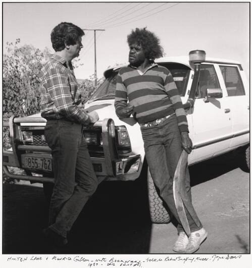 Hinton Lowe and Morris Gibson Tjapaltjarri leaning against a vehicle, Kintore, Northern Territory / Joyce Evans