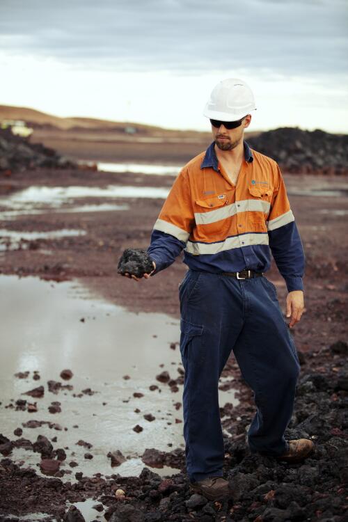 A miner holding raw manganese ore at the bottom of green snake pit at Woodie Woodie Mine, Pilbara, Western Australia, 2012 / Claire Martin