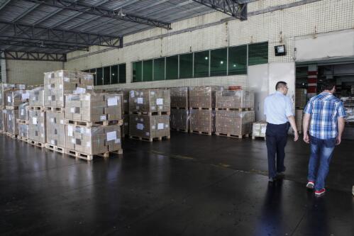 Two employees walking past pallets of books ready for shipment, 1010 Printing Group factory, Guang Dong Province, China, July 2013 / Louise Whelan