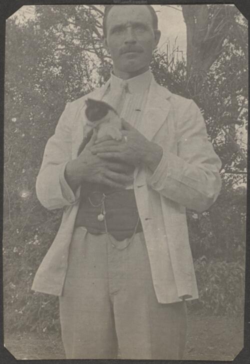 A German dressed in a suit holding a cat, Brisbane / Carl Schiesser