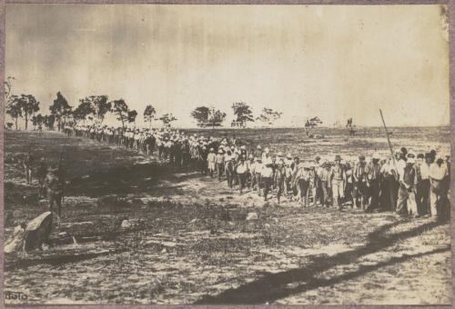 Internees walking in a line outside at the internment camp at Holsworthy, New South Wales, 1918 or 1919 / Carl Schiesser