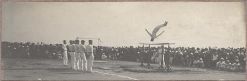 Gymnast dismounting from parallel bars outside at the internment camp at Holsworthy, New South Wales, 1918 or 1919 / Carl Schiesser