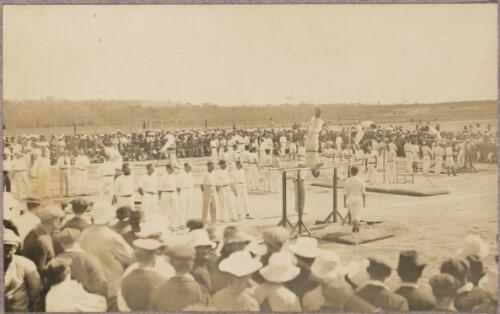 Crowd gathered to watch gymnasts performing on equipment outside at the internment camp at Holsworthy, New South Wales, 1918 or 1919, 1 / Carl Schiesser