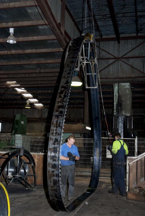 Two saw doctors replacing a saw on a chipper machine at Blue Ridge Hardwoods saw mill, Eden, New South Wales, 2010 / Ruth Maddison