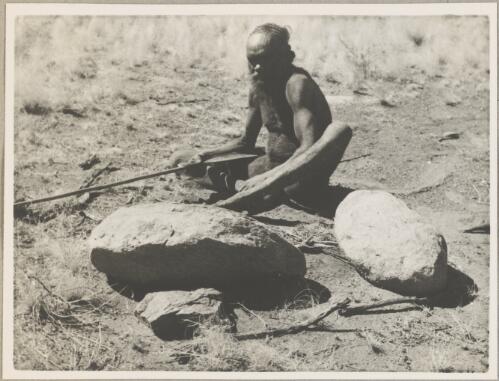 Aboriginal man seated next to boulders representing the source of healthy spirit children at Niunja, Mann Ranges, South Australia, 1940? [picture] / Charles P. Mountford