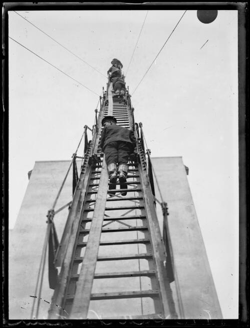 Fire fighters climbing a ladder during a fire drill, New South Wales, ca. 1920 [picture]