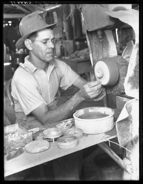 [Unidentified man with grinding wheel] [picture] / [Frank Hurley]