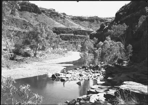[A figure standing on the rocks in the Wittenoom Gorge, Western Australia] [picture] / [Frank Hurley]